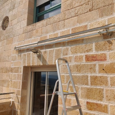 סולם ליד קיר אבן עם מסילה מותקנת