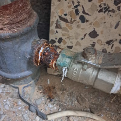 צינור חלוד עם שסתום מתכת על רצפה