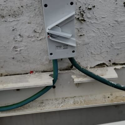 מתג חשמלי עם כבלים ירוקים על קיר