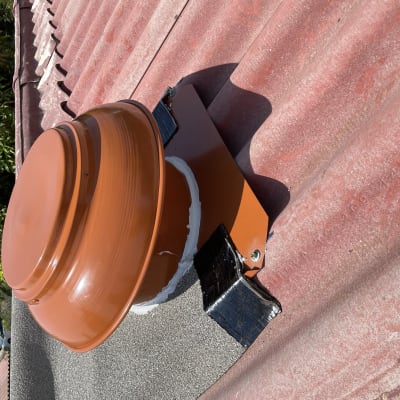 מאוורר כתום מותקן על גג רעפים אדום