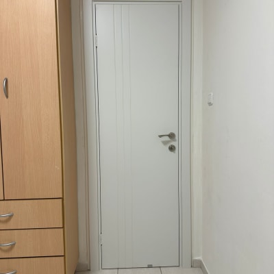 דלת לבנה עם ידית מתכת בחדר פנימי