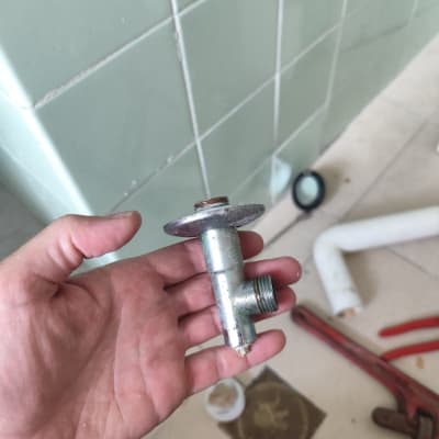 יד מחזיקה חלק מתכת ליד כלים וצינור