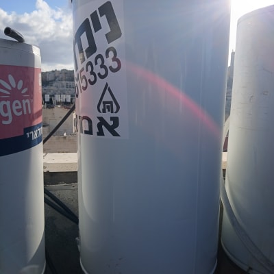 דוד שמש על גג עם מדבקה ושמש ברקע