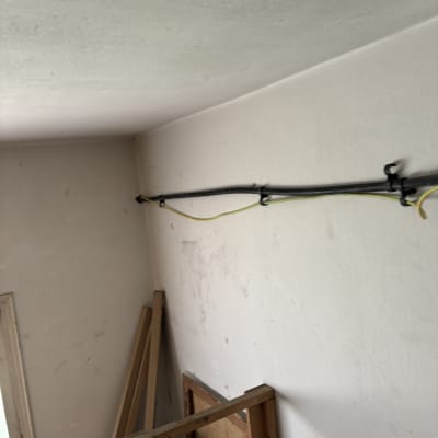 צינור שחור מחובר לקיר עם חוטים צהובים