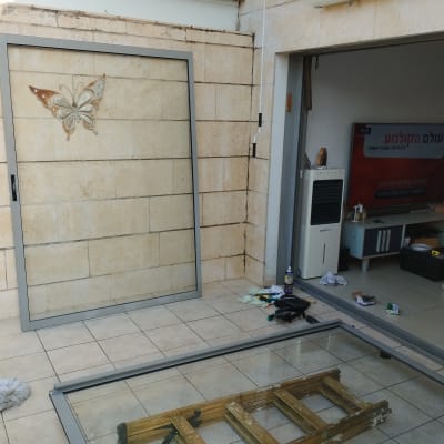 תריסים זכוכית מונחים על הרצפה ליד קיר