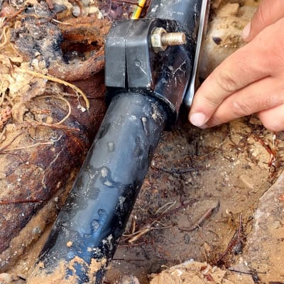 ידיים מתקנות צינור שחור עם כלי עבודה