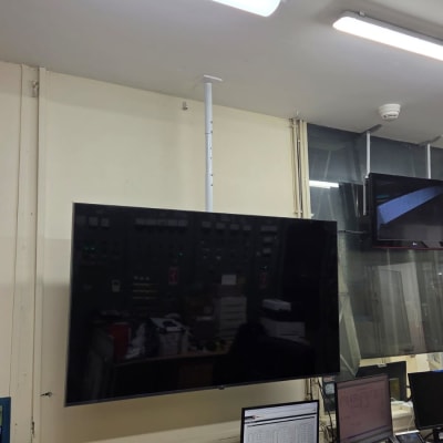 מסך טלוויזיה מותקן על קיר עם כלי עבודה על שולחן