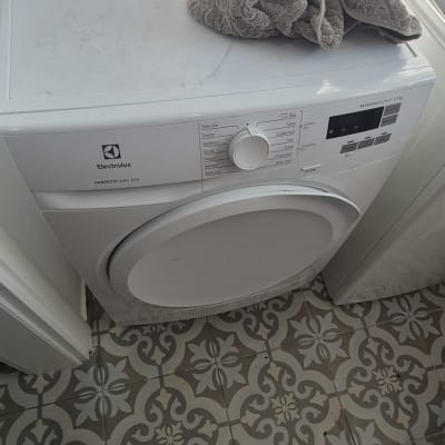 מכונת כביסה אלקטרולוקס עם מגבת על גבי המכונה