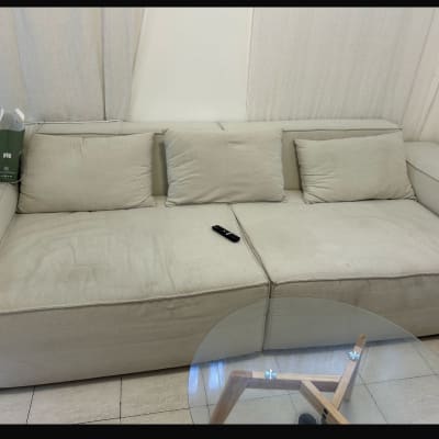 ספה בהירה עם כריות ושלט על המושב