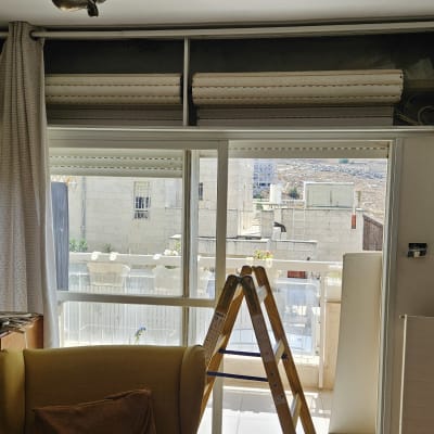 תריסים וחלון עם סולם בחדר פנימי