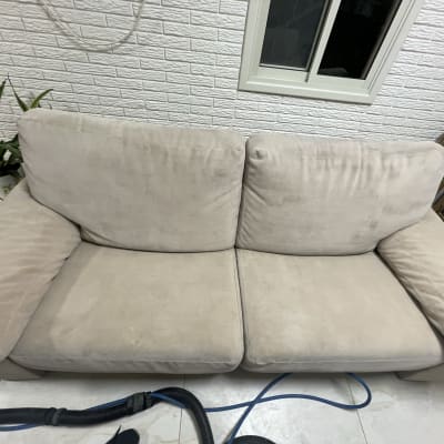 ספה בהירה עם צינור ניקוי על הרצפה