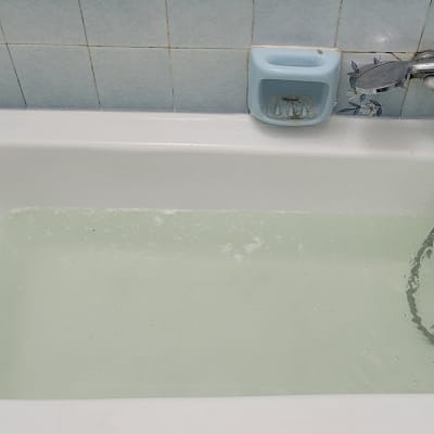 אמבטיה עם מים זורמים, ברז ומחזיק סבון