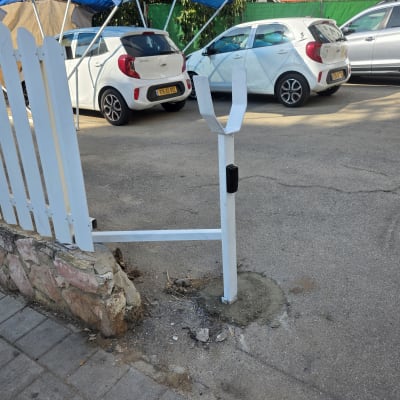 שער חשמלי לבן עם מכונית חונה ברקע