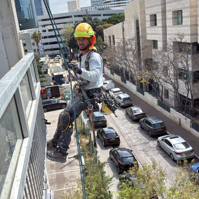 אדם בעבודת גובה על בניין בעיר