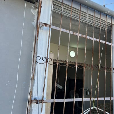 סורגים חלודים עם איטום לבן סביבם