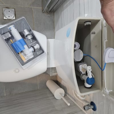 מיכל הדחה פתוח עם חלקי אינסטלציה וכלים