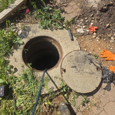 פתח ביוב עם צינור וכלים מסביב