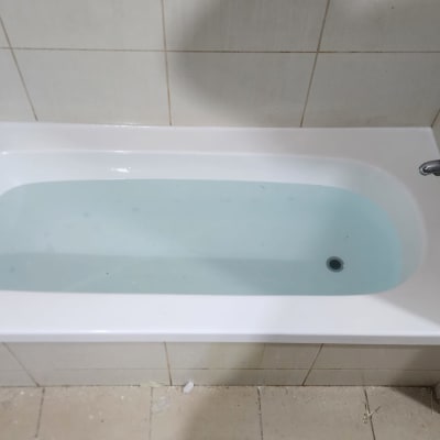 אמבטיה עם מים, ברז מתכת על הקיר