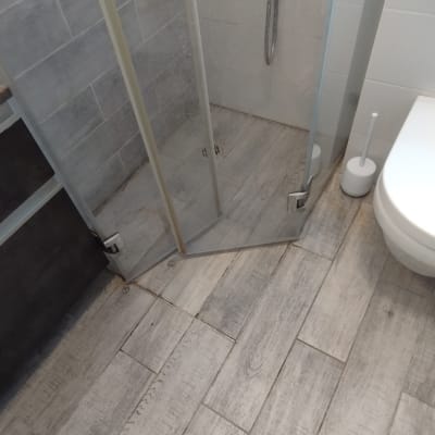 מקלחון זכוכית עם רצפת עץ בחדר אמבטיה