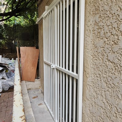 סורגי מתכת לבנים מותקנים על חלון