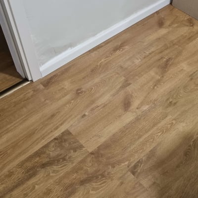 רצפת פרקט עץ חום ליד קיר לבן