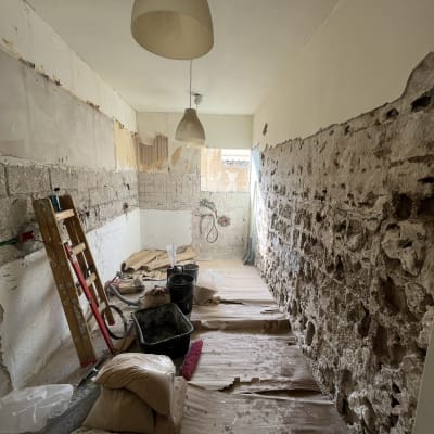 חדר בשיפוץ עם קירות חשופים, סולם ודליים