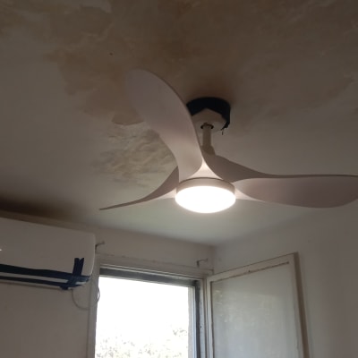 מאוורר תקרה, סולם וכלי צביעה בחדר.