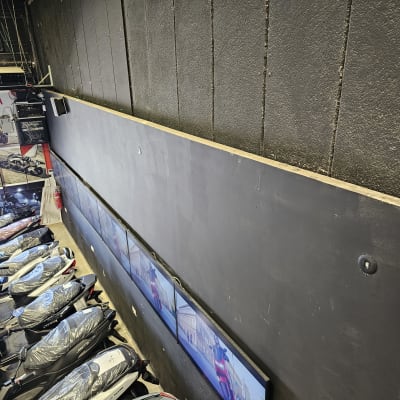 מסכים מותקנים על קיר עם חוטי חשמל גלויים