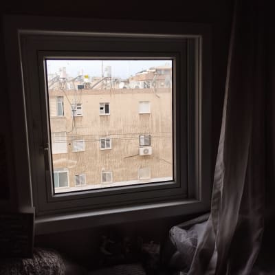 חלון עם תריסים סגורים בבניין ממול