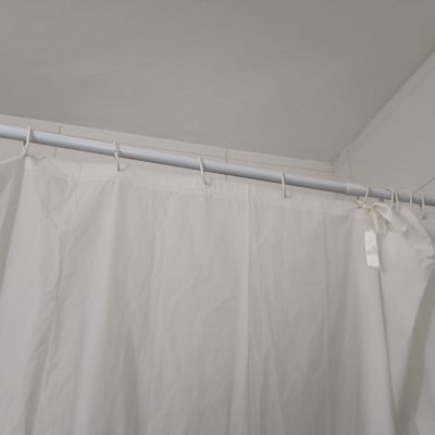 וילון מקלחת תלוי על מוט בחדר אמבטיה