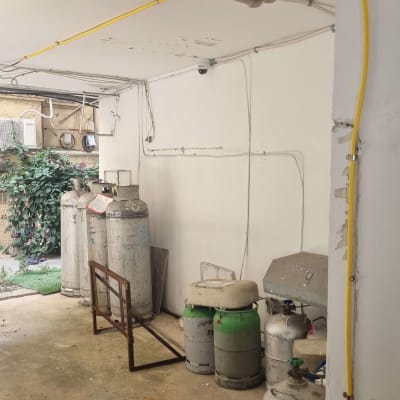 בלוני גז גדולים וקטנים בחדר עם צינורות צהובים