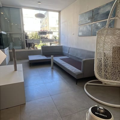 סלון ריק עם ספה, מנורה ותמונות על הקיר