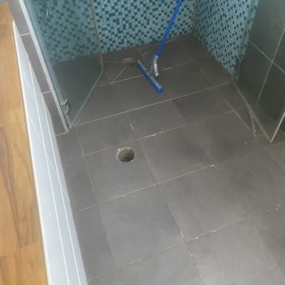 רצפת מקלחת עם פתח ניקוז וכלי ניקוי