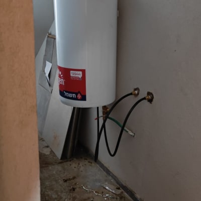 דוד שמש מותקן על קיר עם צינורות חיבור