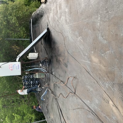 אדם עובד על איטום גג עם יריעות ביטומניות.