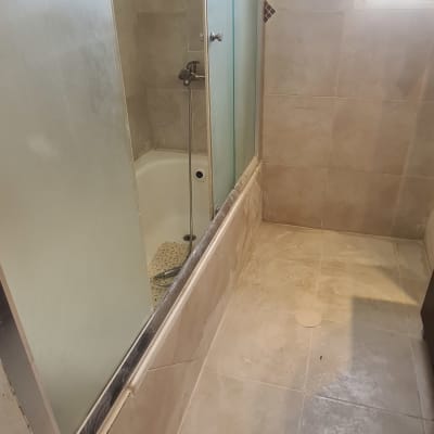 אמבטיה עם דלת זכוכית וברז מקלחת