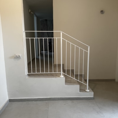 מעקה מתכת לבן על מדרגות פנימיות