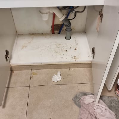 ארון מטבח פתוח עם צנרת מתחת לכיור