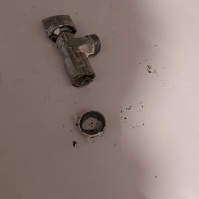 חלקי צנרת מתכת מנותקים על משטח לבן