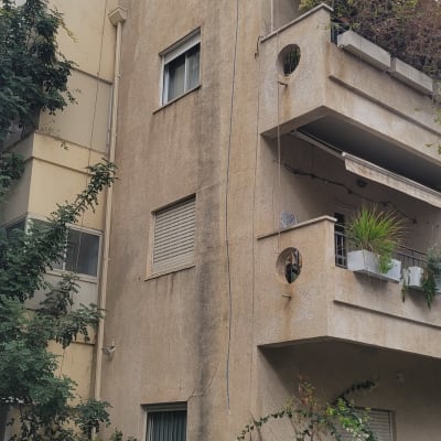 אדם מטפס על בניין עם ציוד טיפוס וחבלים