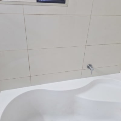 ברז אמבטיה מותקן על קיר אריחים לבנים