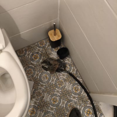 רצפת חדר אמבטיה עם כלי ניקוי וצינור