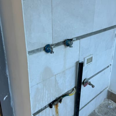 ברזים וצנרת על קיר אריחים