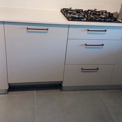 ארונות מטבח עם ידיות מתכת וכיריים גז