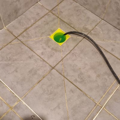 רצפת מקלחת עם צינור ונוזל ירוק