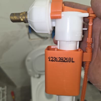 שסתום פלסטיק עם חיבורי מתכת ליד אסלה