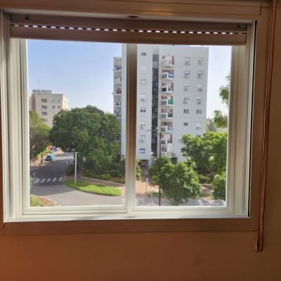 חלון אלומיניום עם נוף עירוני ברקע