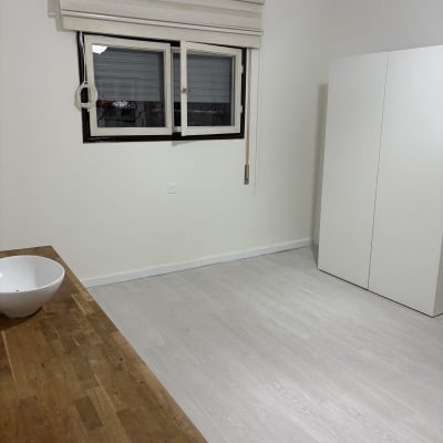 חדר נקי עם רצפת עץ, חלון וארון לבן