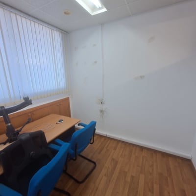 חדר עם קיר לבן וכתמים, שולחן וכיסאות כחולים