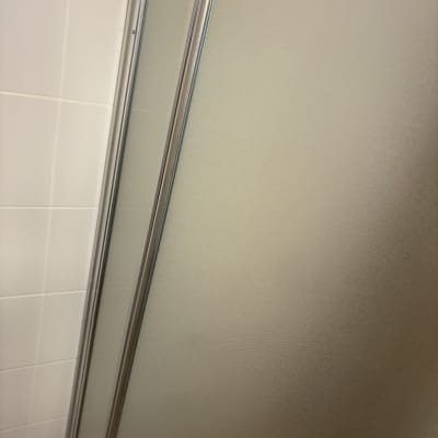 דלת מקלחת מזכוכית עם מסגרת מתכת